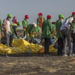 Workers collect debris on March 12, 2019 at the scene where an Ethiopian Airlines Boeing 737 Max 8 crashed shortly after takeoff, killing all 157 on board, near Bishoftu, or Debre Zeit, south of Addis Ababa, in Ethiopia. (AP Photo/Mulugeta Ayene, File)