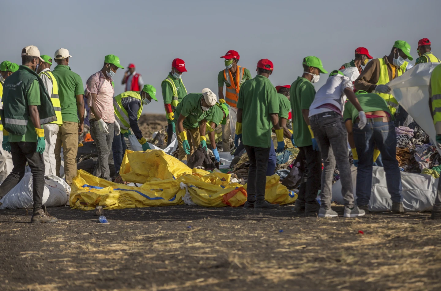Workers collect debris on March 12, 2019 at the scene where an Ethiopian Airlines Boeing 737 Max 8 crashed shortly after takeoff, killing all 157 on board, near Bishoftu, or Debre Zeit, south of Addis Ababa, in Ethiopia. (AP Photo/Mulugeta Ayene, File)